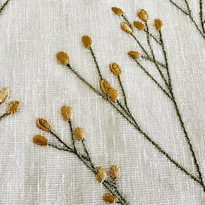 May include: White fabric with a delicate embroidered design of green stems and gold leaves.