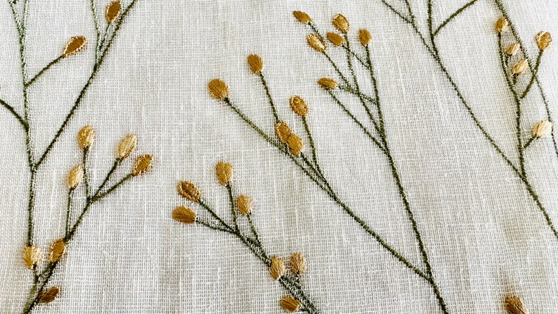 May include: White fabric with a delicate embroidered design of green stems and gold leaves.