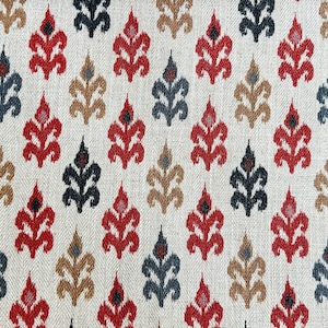 May include: A white fabric with a repeating pattern of red, black, and brown stylized floral motifs. The fabric has a subtle herringbone weave.