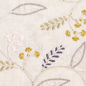 May include: White fabric with embroidered floral designs in shades of gray, white, yellow, and blue.