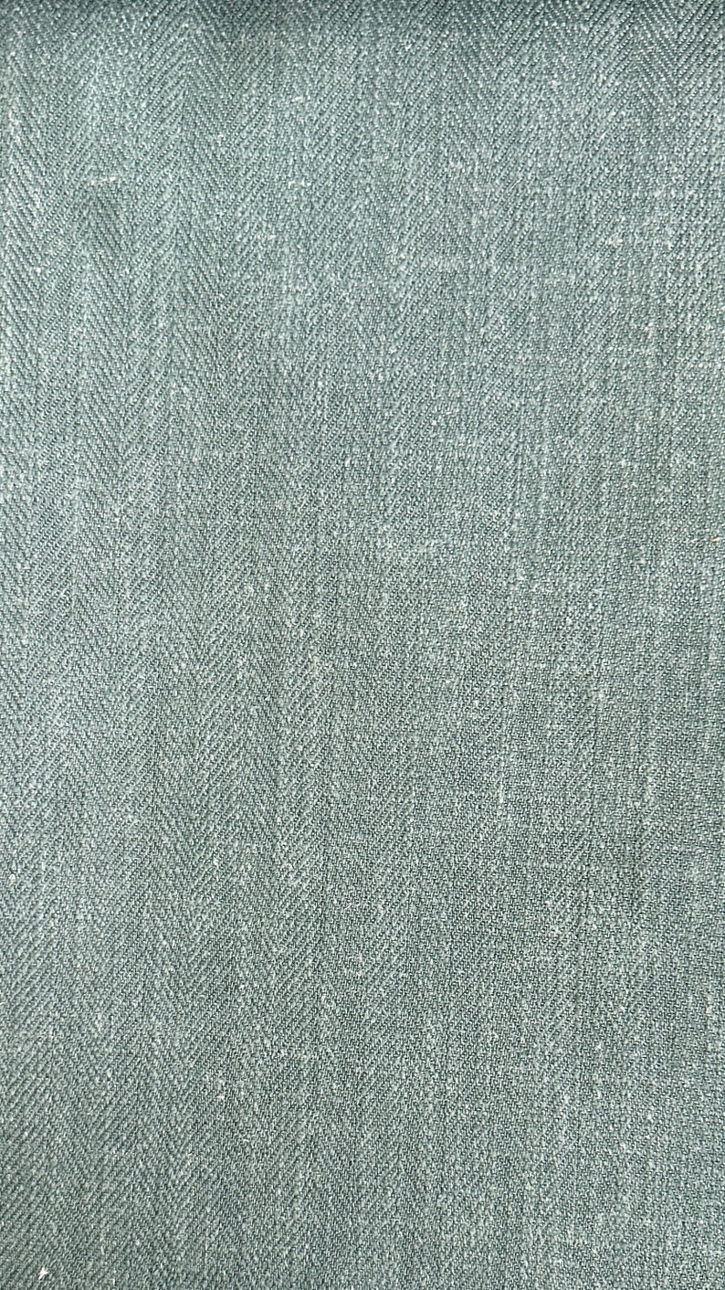 May include: A close-up of a gray herringbone fabric with a subtle texture.