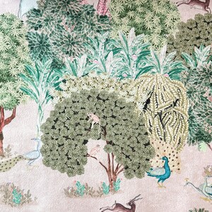 May include: A pink background with a green and white floral pattern. The pattern includes peacocks, deer, monkeys, and birds. The design is reminiscent of a traditional Indian textile.