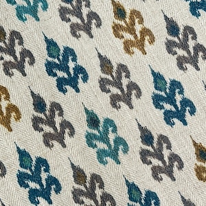 May include: A white fabric with a repeating pattern of stylized leaves in shades of teal, gray, and gold.