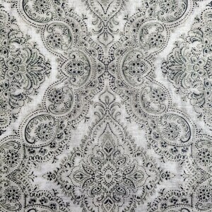 May include: A white fabric with a black and gray paisley pattern. The pattern is intricate and detailed, with a repeating design of paisley shapes and floral motifs.