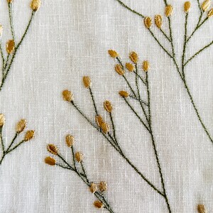May include: White fabric with a delicate embroidered pattern of green stems and gold leaves.