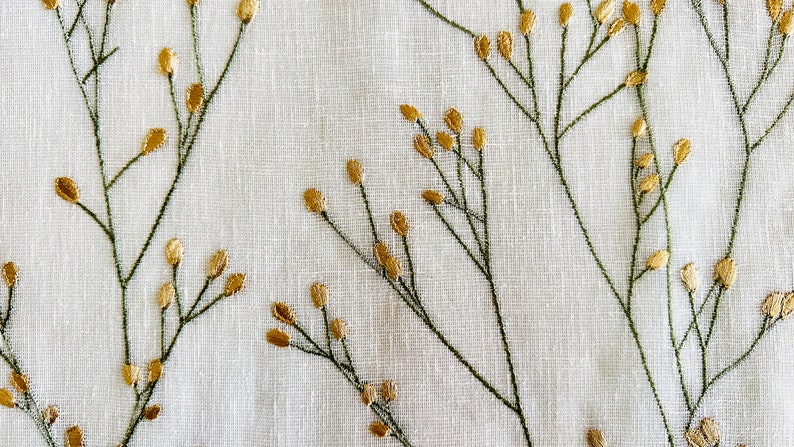 May include: White fabric with a delicate embroidered pattern of green stems and gold leaves.