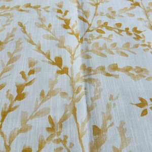 May include: White fabric with a subtle, repeating pattern of gold-colored leaves and branches.