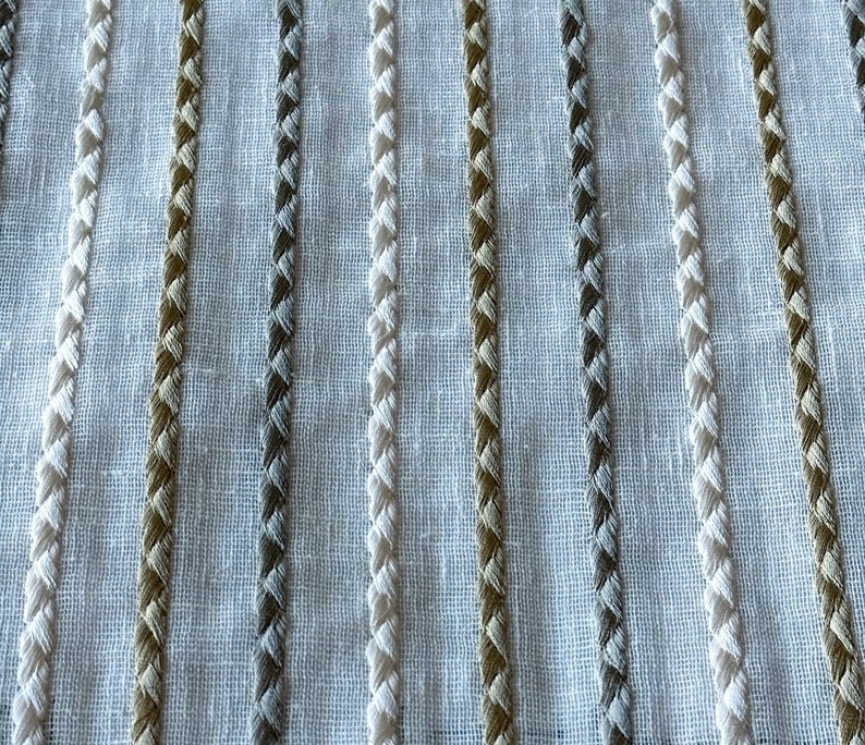 May include: White fabric with vertical stripes of woven brown, gray, and white thread.