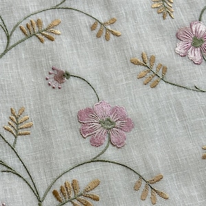 Puede incluir: Tela blanca transparente con flores rosas y verdes y hojas doradas bordadas.