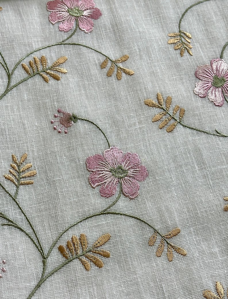Puede incluir: Tela blanca transparente con flores rosas y verdes y hojas doradas bordadas.