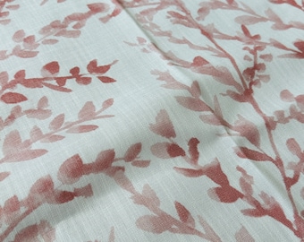 May include: A white fabric with a repeating pattern of pink floral sprigs. The fabric has a subtle texture.