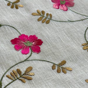 May include: White fabric with embroidered pink flowers and gold leaves. The fabric has a subtle texture.