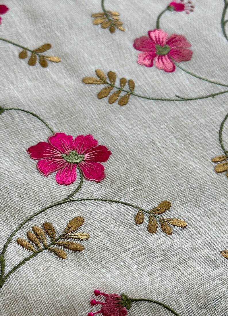 May include: White fabric with embroidered pink flowers and gold leaves. The fabric has a subtle texture.