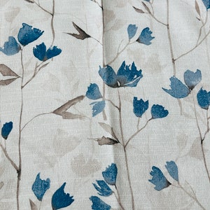 Pu&ograve; includere: Un tessuto bianco con un motivo floreale blu. I fiori sono stilizzati e assomigliano a dipinti ad acquerello.