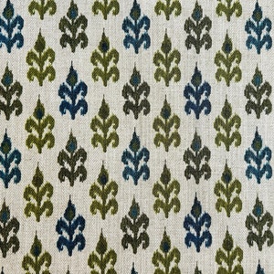 May include: A white fabric with a repeating pattern of green and blue stylized leaves. The fabric has a subtle herringbone weave.