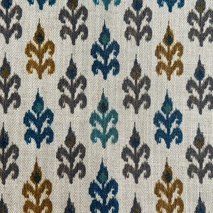 May include: A white fabric with a repeating pattern of blue, teal, brown, and gold stylized floral designs.