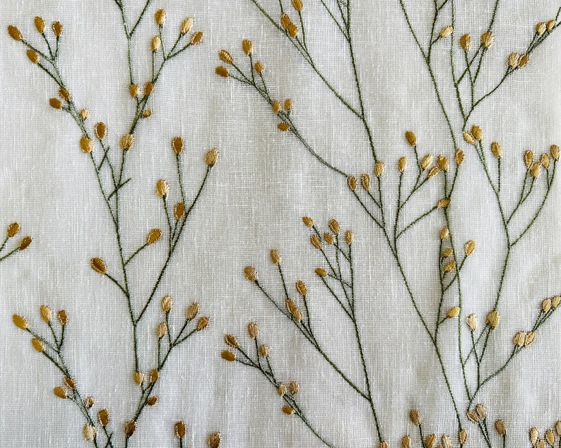 May include: White fabric with an embroidered pattern of green stems and gold leaves.