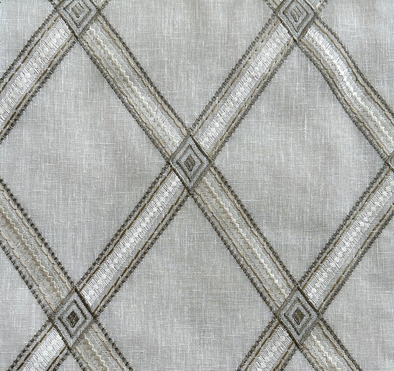 May include: A white fabric with a diamond pattern woven in a brown and white thread.