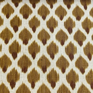 May include: A white fabric with a brown and rust colored ikat pattern.