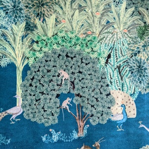 May include: A teal blue background with a large green tree in the center. The tree has two monkeys climbing on it. There are peacocks and a deer on the ground. The background is filled with green leaves and flowers.