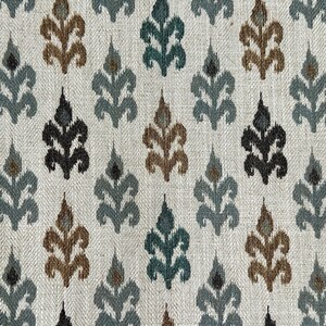 May include: A white fabric with a repeating pattern of stylized leaves in shades of teal, brown, gray, and black.