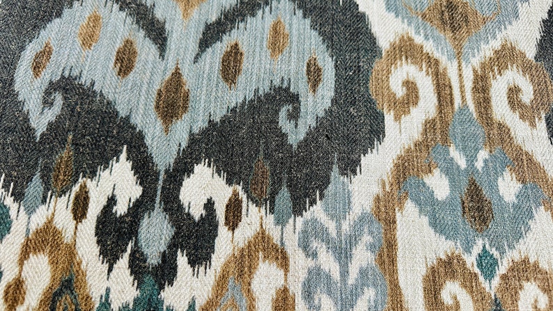 Puede incluir: Primer plano de una tela con un patr&oacute;n ikat azul, marr&oacute;n y blanco. La tela tiene una textura tejida y un brillo sutil.