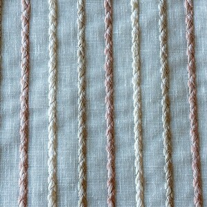 Puede incluir: Primer plano de una tela tejida con rayas verticales en beige y rosa claro.