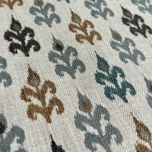 May include: A white fabric with a repeating pattern of blue, brown, and black stylized floral designs.