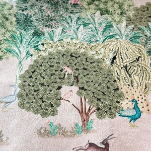 May include: A beige background with a green and brown tree in the center. Two small monkeys are climbing the tree. A peacock with blue and green feathers is standing on the right side of the image. A deer is jumping in the bottom right corner of the image.
