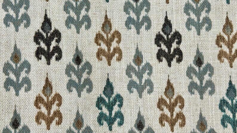 May include: A white fabric with a repeating pattern of blue, brown, and black stylized floral designs.