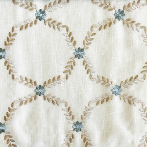 May include: White fabric with a repeating pattern of embroidered brown leaves and blue flowers.