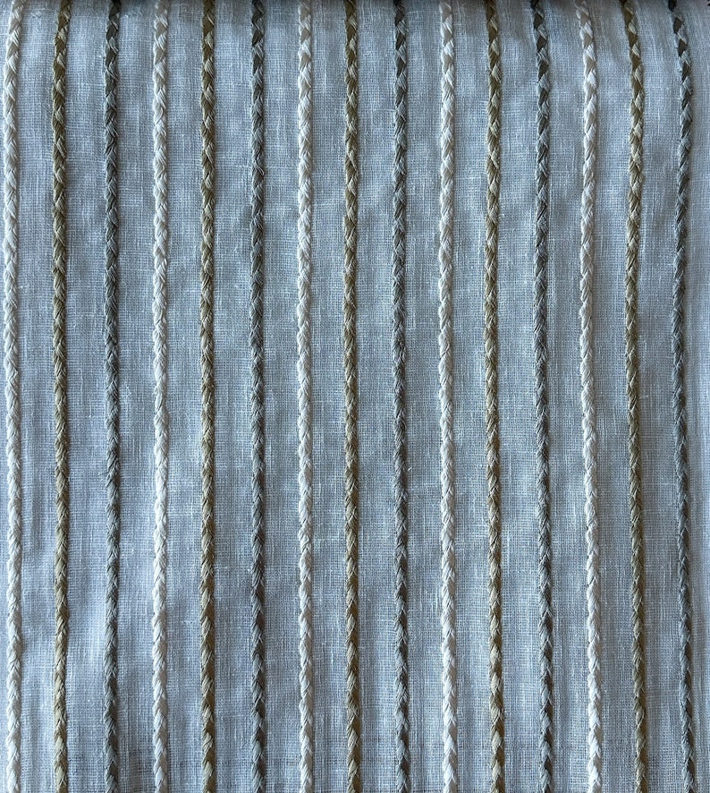 May include: White fabric with vertical stripes of different shades of brown and gray.