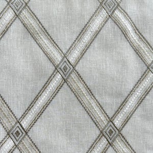 May include: A white fabric with a diamond pattern woven in a light brown thread.