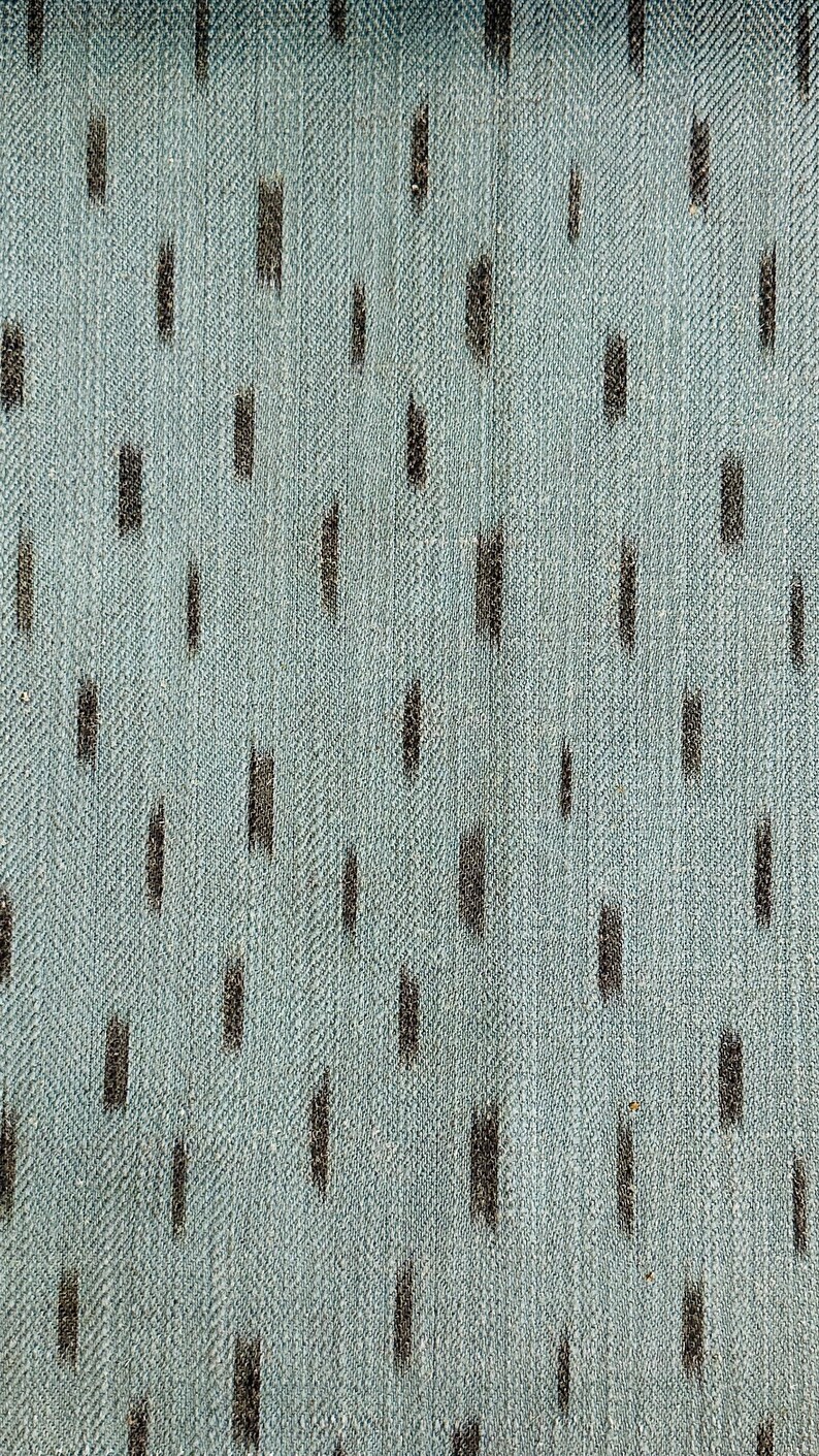 Puede incluir: Primer plano de una tela azul claro con un patr&oacute;n sutil y repetitivo de l&iacute;neas verticales gris oscuro.