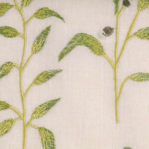 May include: A white fabric with an embroidered green leafy pattern.