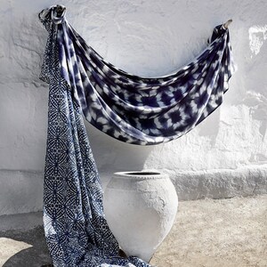 May include: A white ceramic pot with a blue and white patterned fabric draped over it. The fabric has a tie-dye pattern and a geometric pattern.