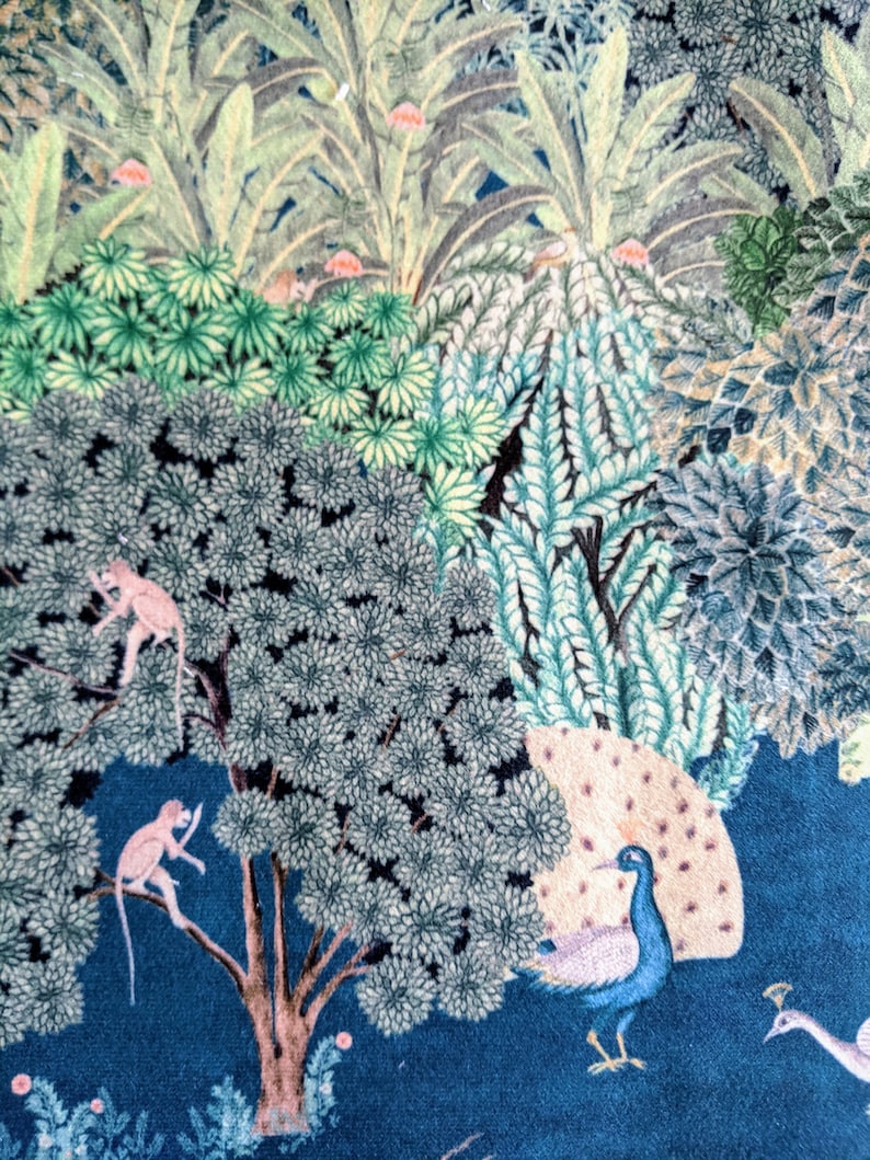 May include: A blue and green patterned fabric with a peacock, two monkeys, and various trees. The fabric has a vintage style and is perfect for crafting projects.
