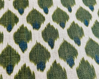 May include: A white fabric with a repeating pattern of green and blue teardrop shapes.