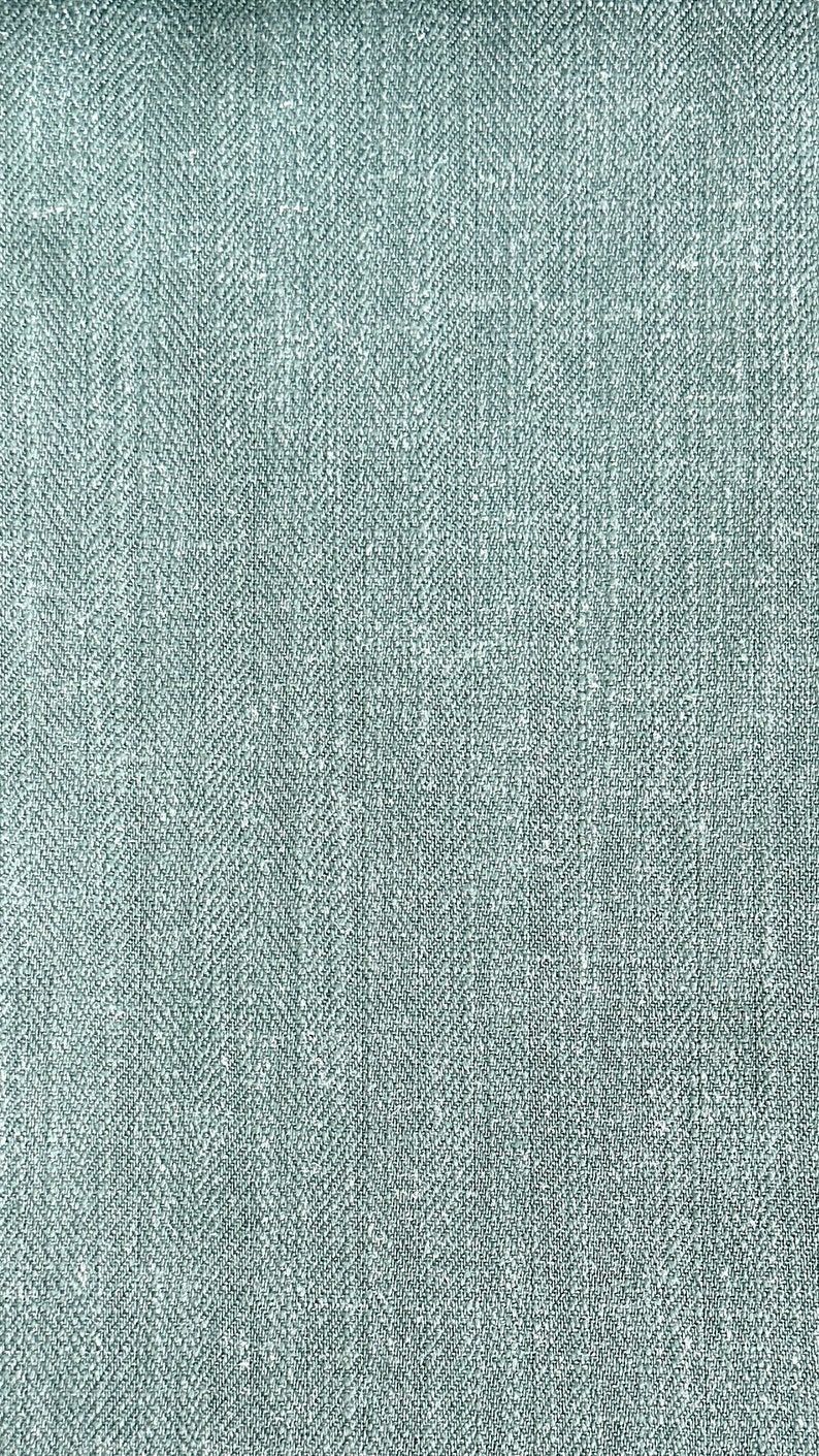 May include: A close-up of a light blue fabric with a herringbone weave pattern.