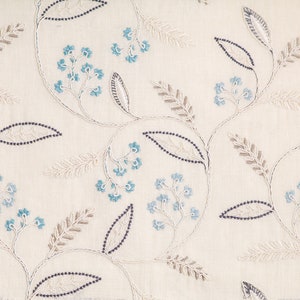 Puede incluir: Tela color crema con un patr&oacute;n floral bordado. El dise&ntilde;o presenta delicadas flores azules, hojas de color gris-marr&oacute;n y tallos punteados azul oscuro. El bordado crea un aspecto texturizado y elegante, adecuado para la decoraci&oacute;n del hogar.
