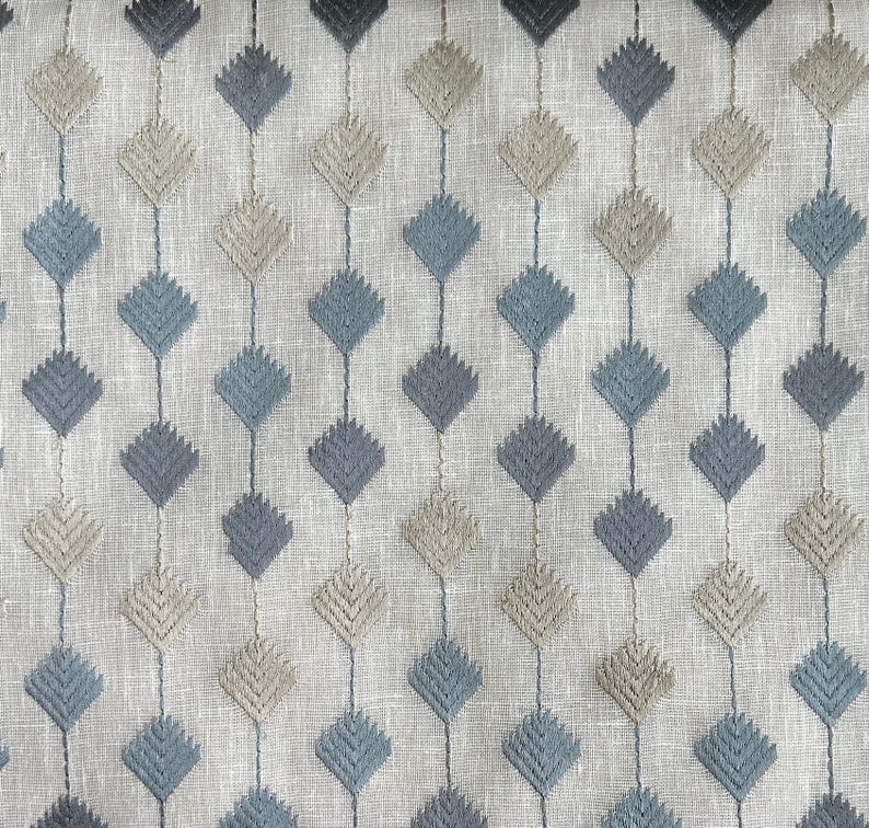 Puede incluir: Primer plano de una tela con un patr&oacute;n repetido de formas de diamante en tonos azules y beige. La tela tiene una textura de lino sutil.