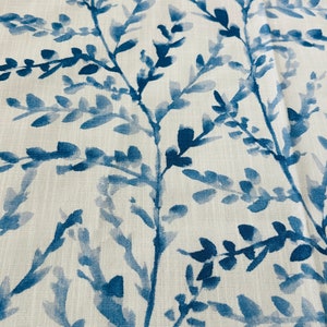 May include: Close-up of a fabric with a repeating pattern of blue watercolor-style branches and leaves against a white background. The design has a natural, organic feel, suitable for home decor or apparel.