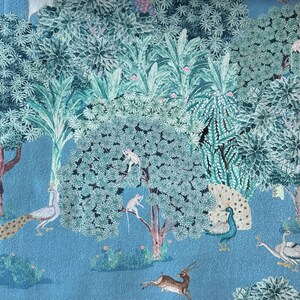 May include: A blue and green patterned fabric featuring a peacock, deer, and monkeys in a jungle setting.