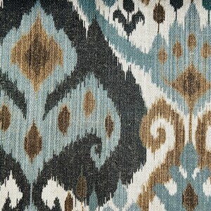 Puede incluir: Primer plano de una tela con un patr&oacute;n ikat azul, marr&oacute;n y blanco. La tela tiene una superficie texturizada y un aspecto tejido.