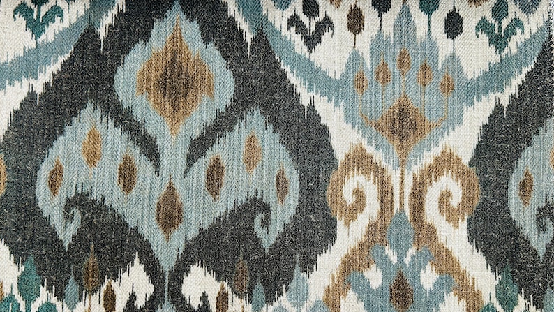 Puede incluir: Primer plano de una tela con un patr&oacute;n ikat azul, marr&oacute;n y blanco. La tela tiene una superficie texturizada y un aspecto tejido.