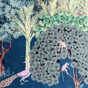 May include: A blue fabric with a colorful jungle scene featuring a peacock, monkeys, and trees. The fabric has a vintage style.