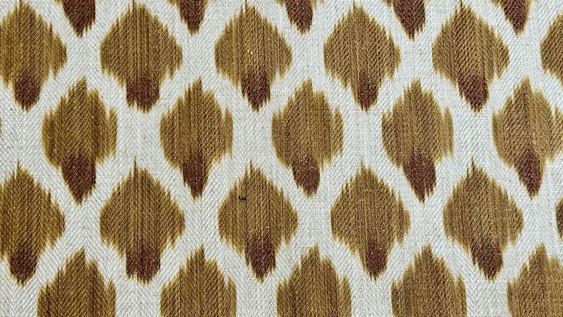 May include: White fabric with a repeating pattern of brown and tan ikat-style diamonds.