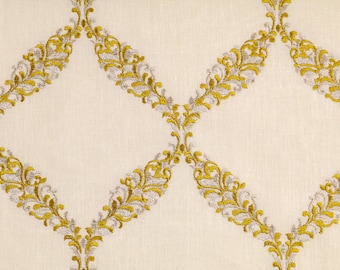 May include: A white fabric with a repeating pattern of gold and silver embroidered diamond shapes. The diamond shapes are made up of a series of stylized floral motifs.