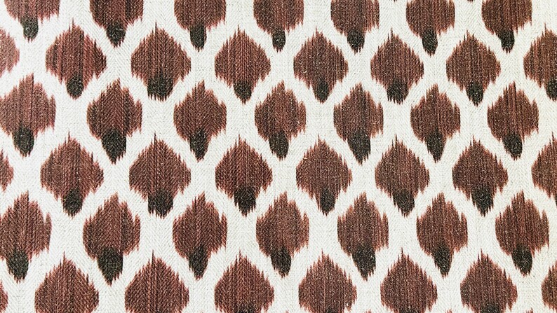 May include: Brown and white fabric with a repeating pattern of brown diamond shapes. The fabric has a textured, woven look.