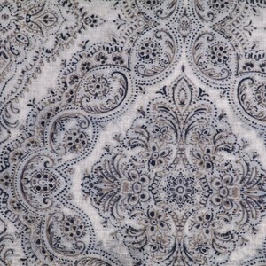 May include: A white fabric with a paisley pattern in shades of brown and black.